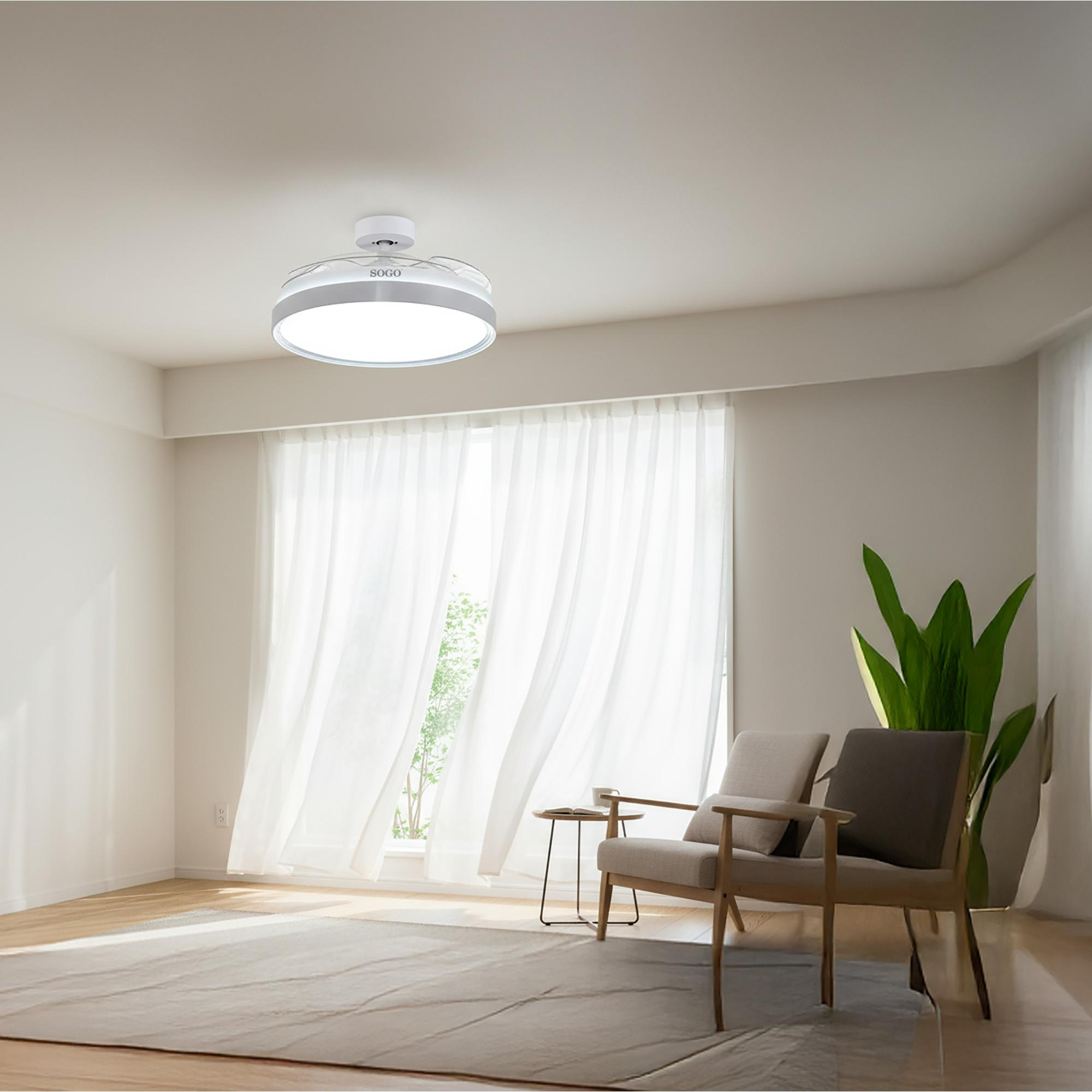 Una habitación luminosa con dos sillones, una alfombra, una mesa y un ventilador de techo.