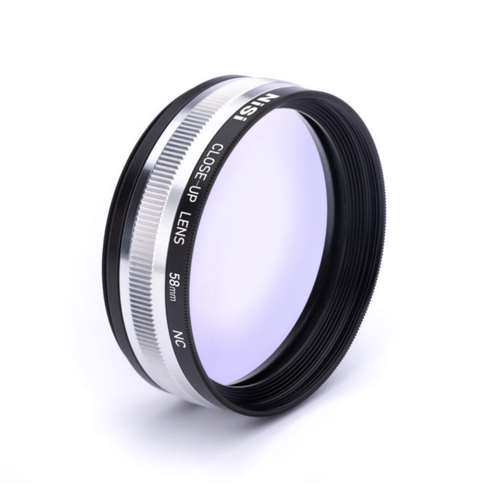 Een Nisi 58mm close-up lens met een zilveren rand en paars glas.