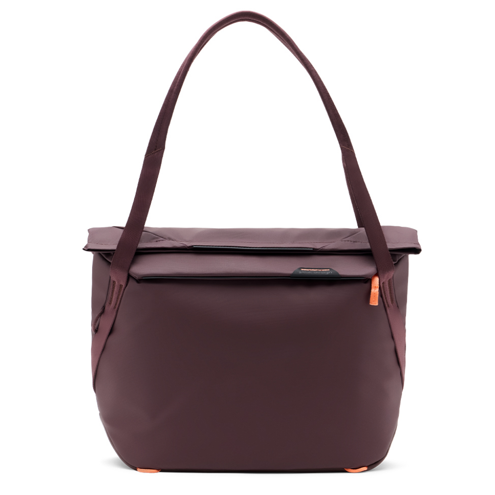 Een bordeauxrode tote tas met een oranje ritslipje.