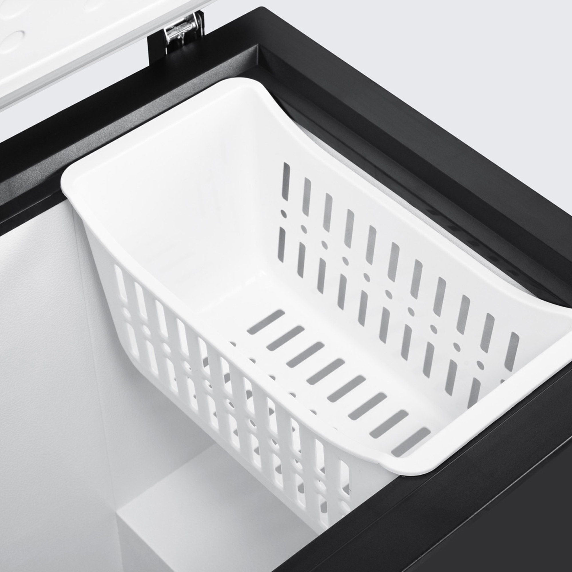 Séparateur blanc amovible avec fentes dans un congélateur noir.