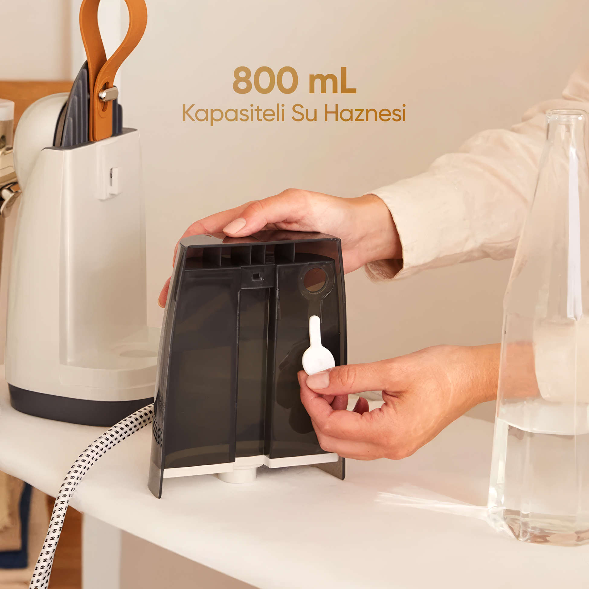 Bir kişi 800 ml kapasiteli buharlı ütü su haznesini dolduruyor.