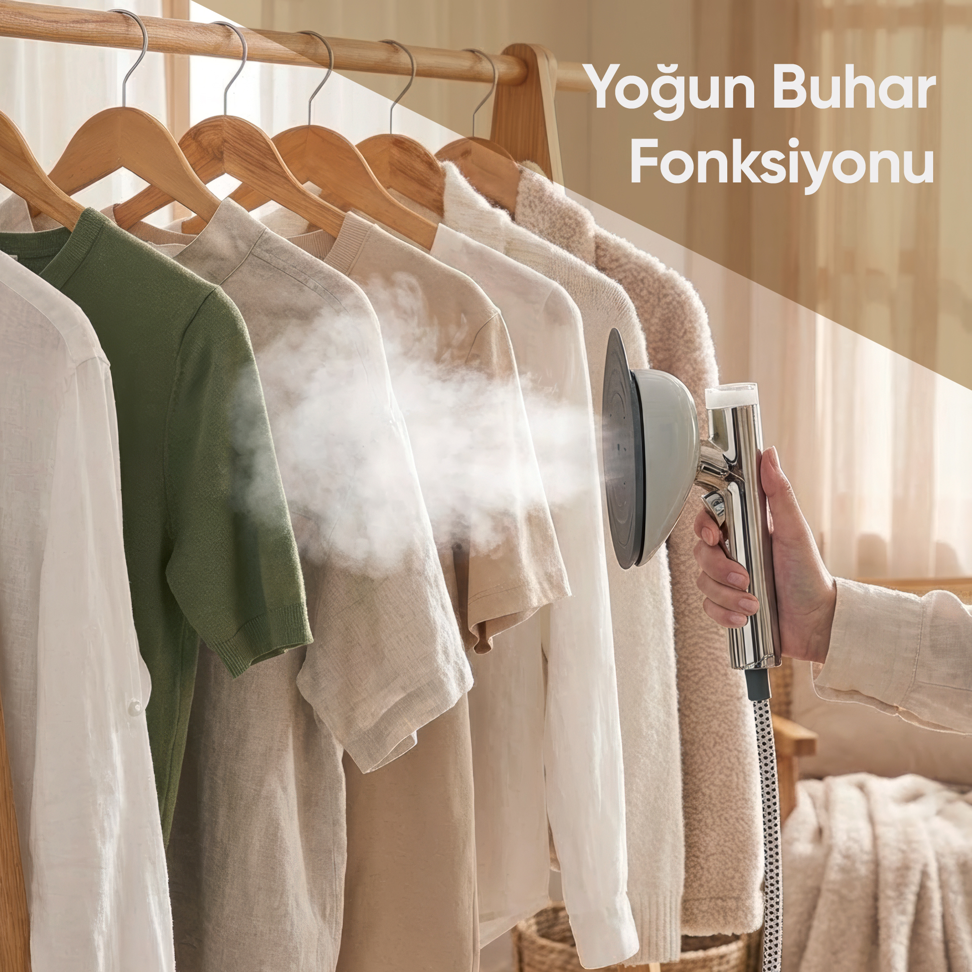 Bir el, askıdaki giysilere buhar tutan bir giysi buharlayıcı tutuyor.
