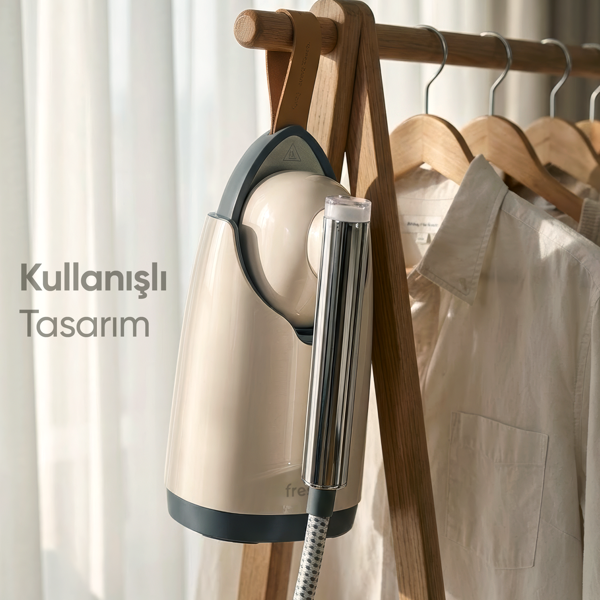Krem rengi bir buharlı temizleyici, gömleklerin yanında ahşap askılıkta asılı.