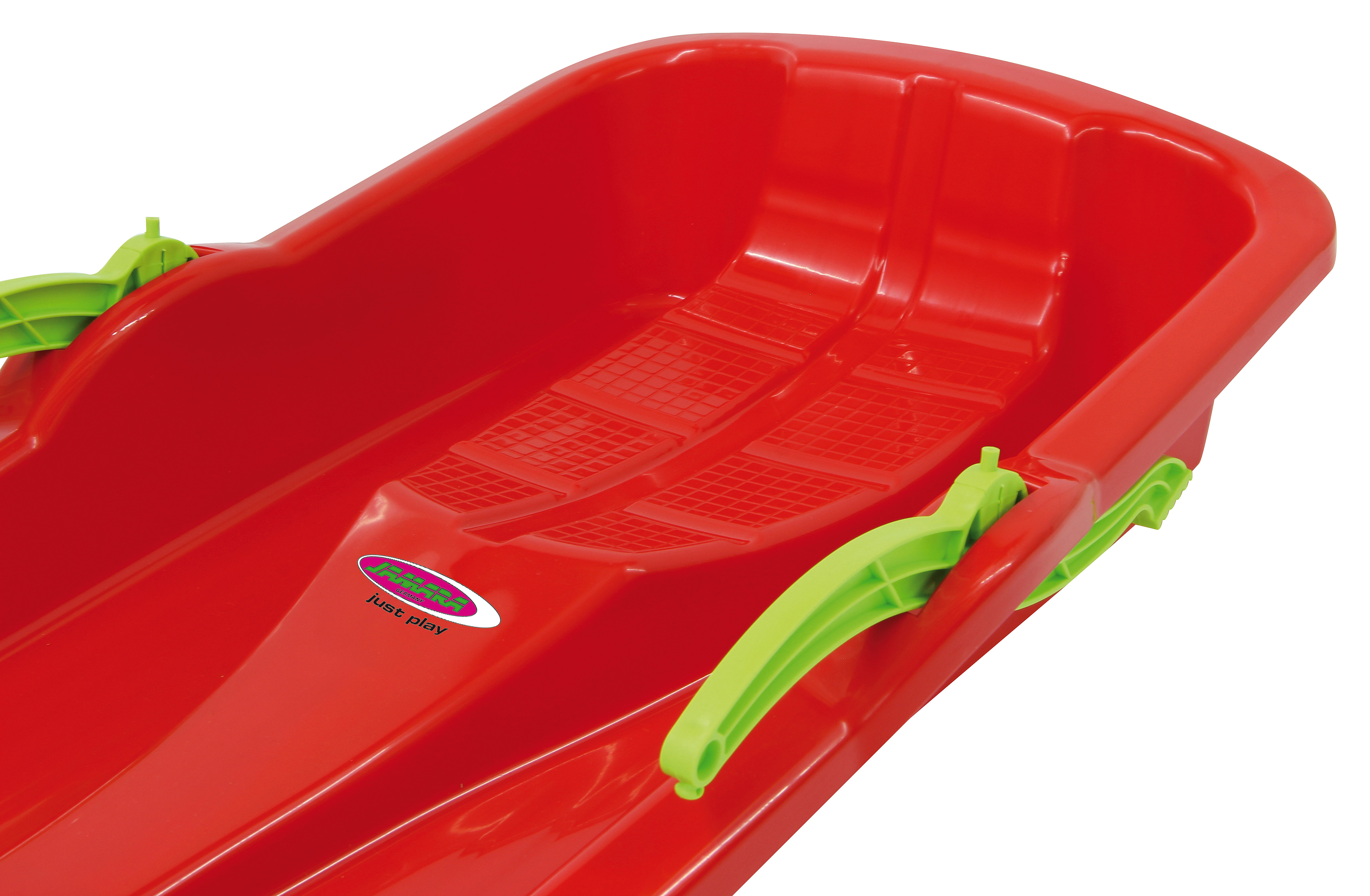 Rotes Plastik-Schlitten mit grünen Griffen und Gittermuster-Sitzfläche.