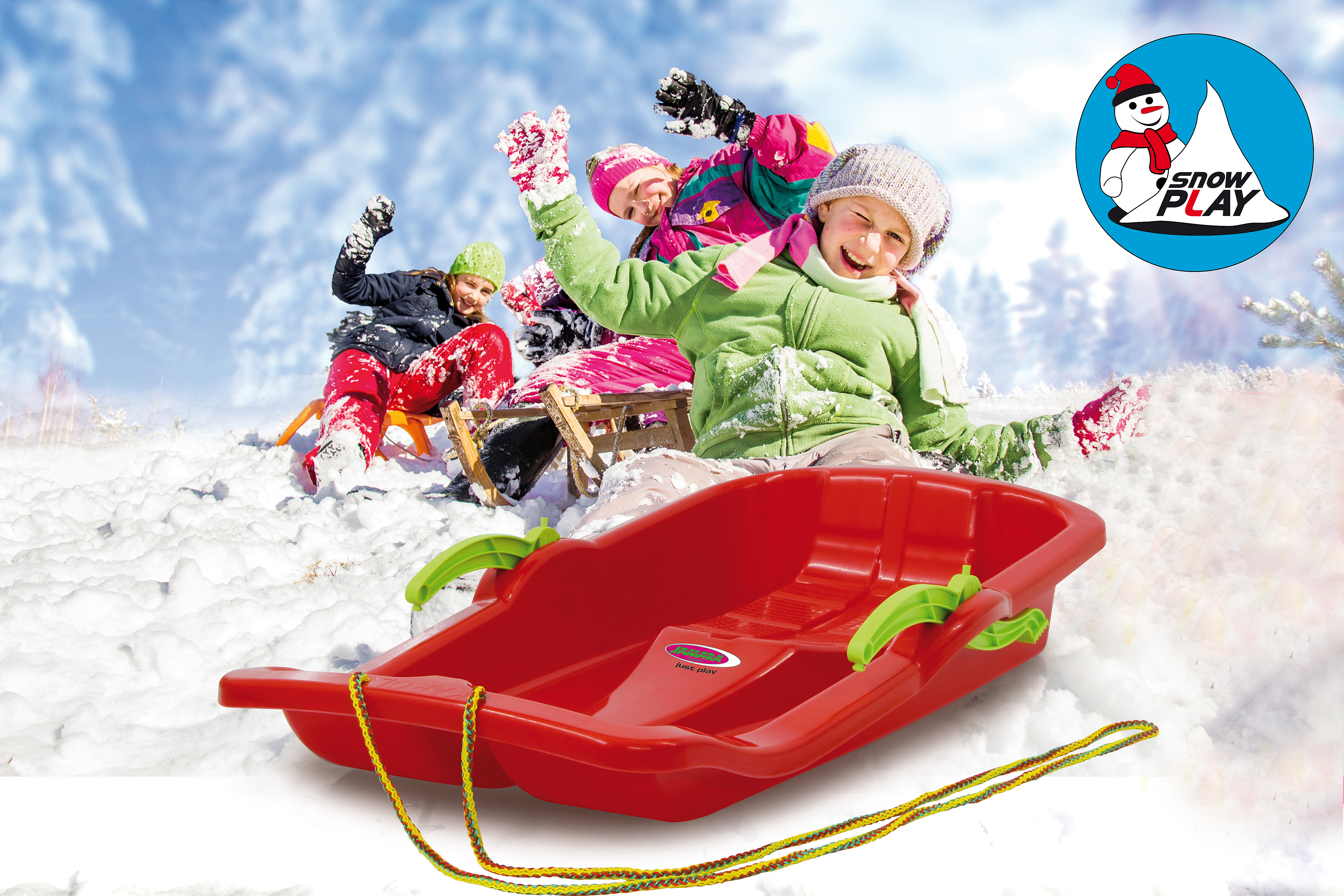 Kinder rodeln im Schnee mit einem roten Schlitten, verschwommener Hintergrund.