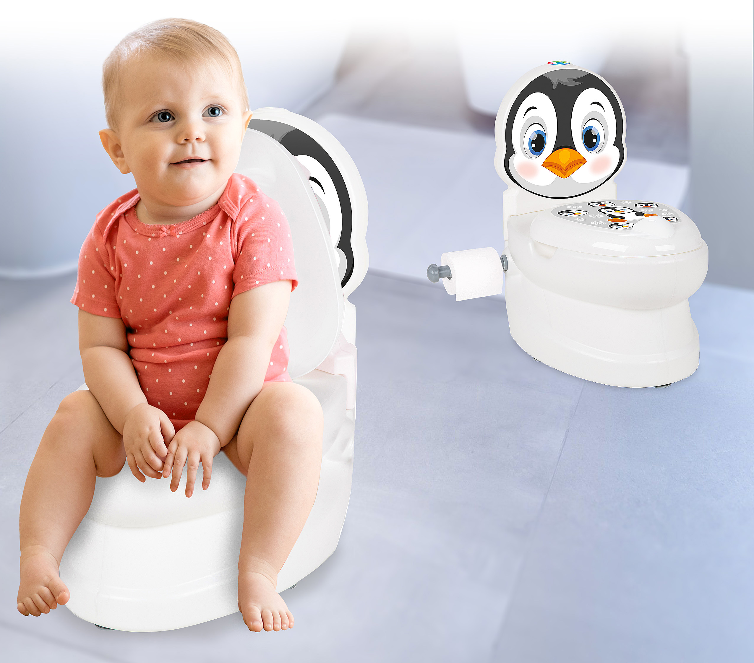 Ein Baby sitzt auf einer rosa gepunkteten Unterlage auf einem Töpfchen. Rechts daneben steht ein Pinguin-Töpfchen.