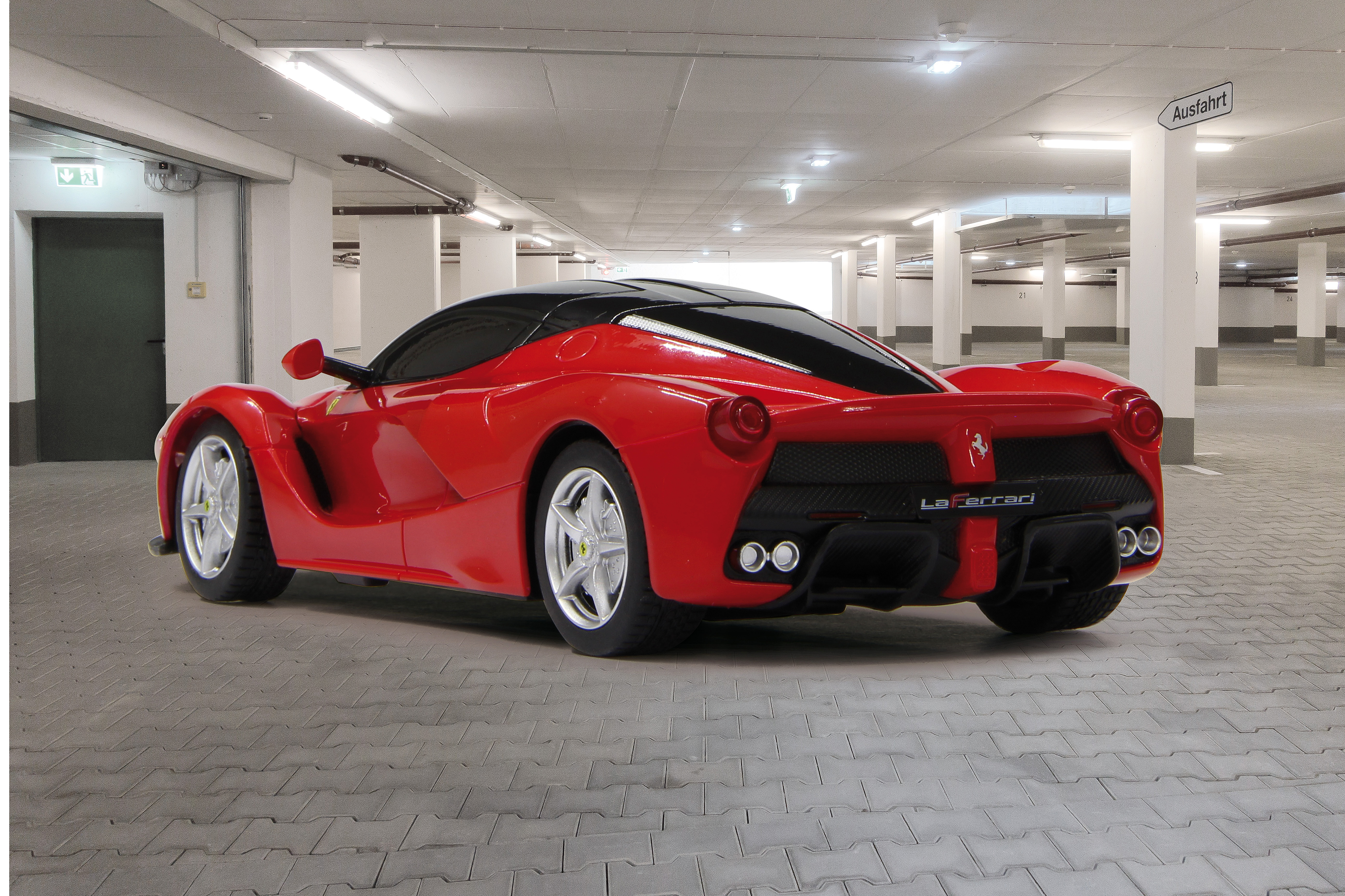 Czerwony Ferrari stoi zaparkowany w podziemnym garażu z betonowymi filarami.