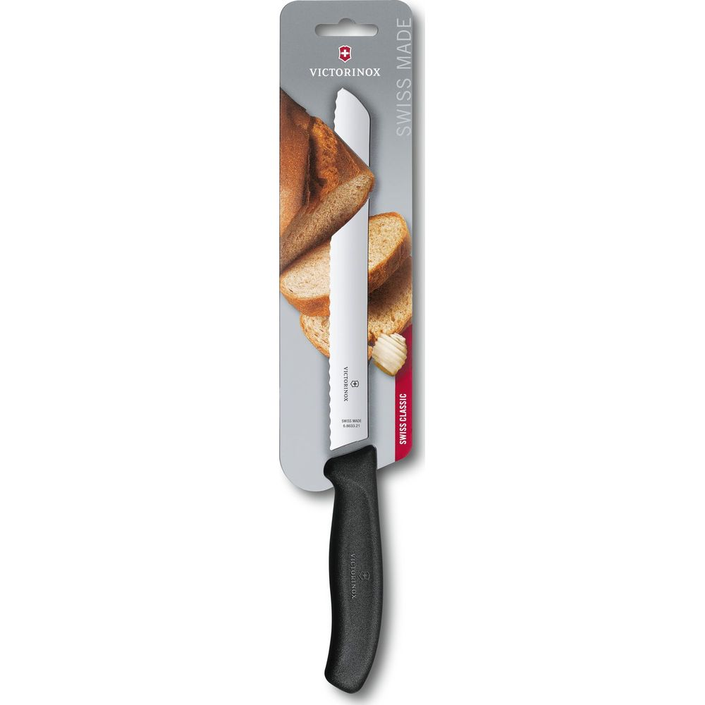 Siyah saplı ve tırtıklı bıçaklı Victorinox ekmek bıçağı, dilimlenmiş ekmeklerin yanında paketlenmiş.