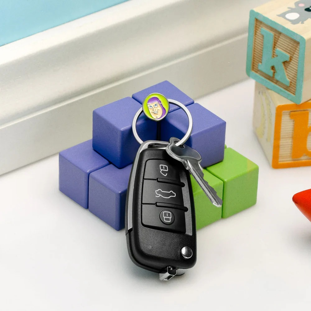 Un portachiavi per auto con ciondolo Buzz Lightyear su blocchi da costruzione viola e verdi.
