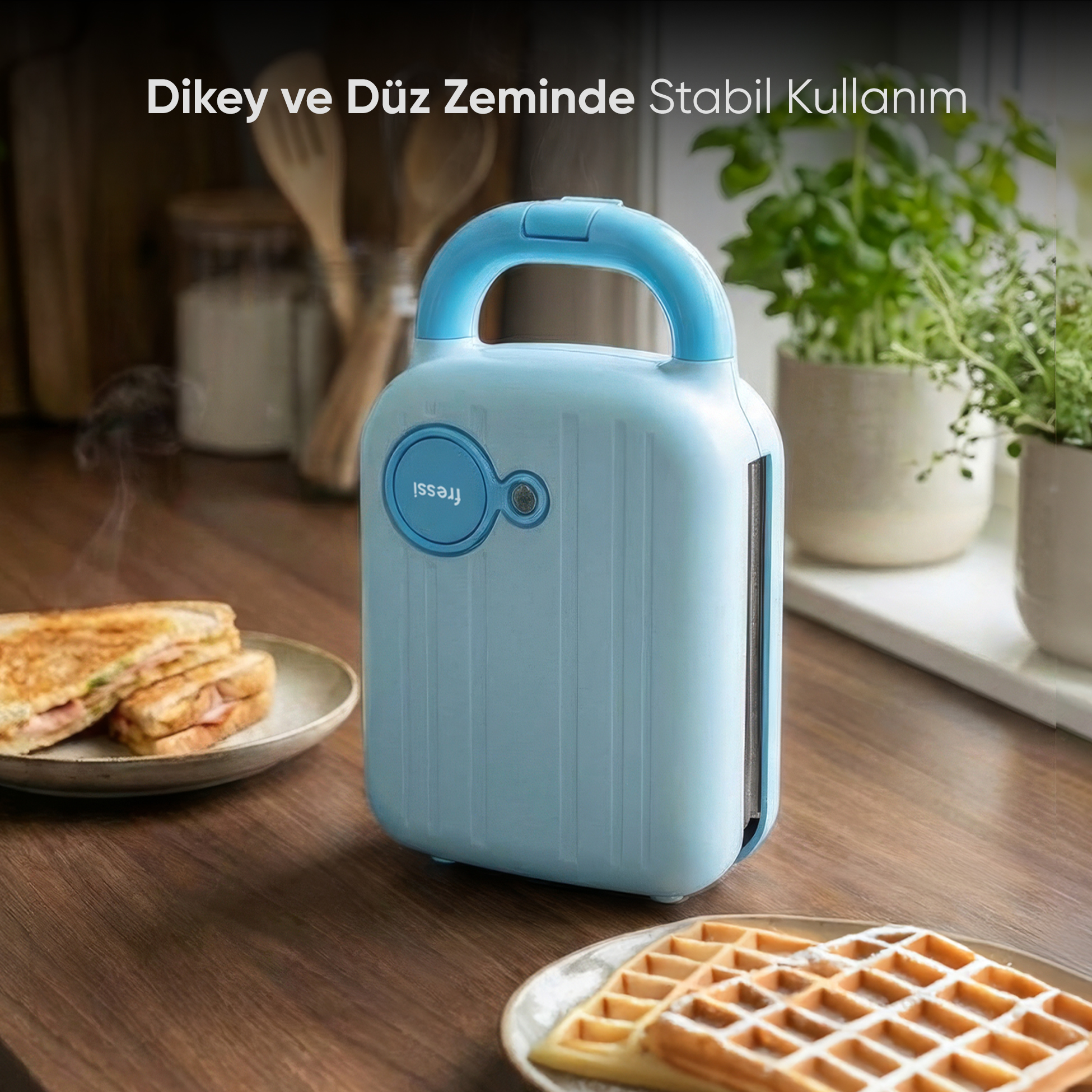 Kulplu açık mavi sandviç makinesi ahşap yüzeyde duruyor, yanında sandviçler ve waffle'lar var.