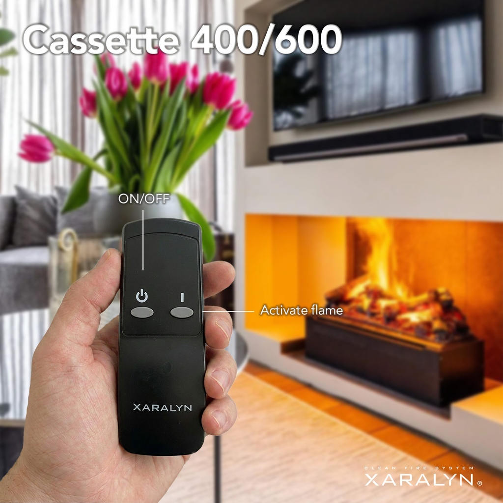 A hand holds a remote in front of a fireplace with flames and pink tulips.
