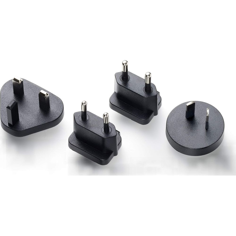 Vier schwarze Reisestecker mit Metallstiften auf weißem Hintergrund.