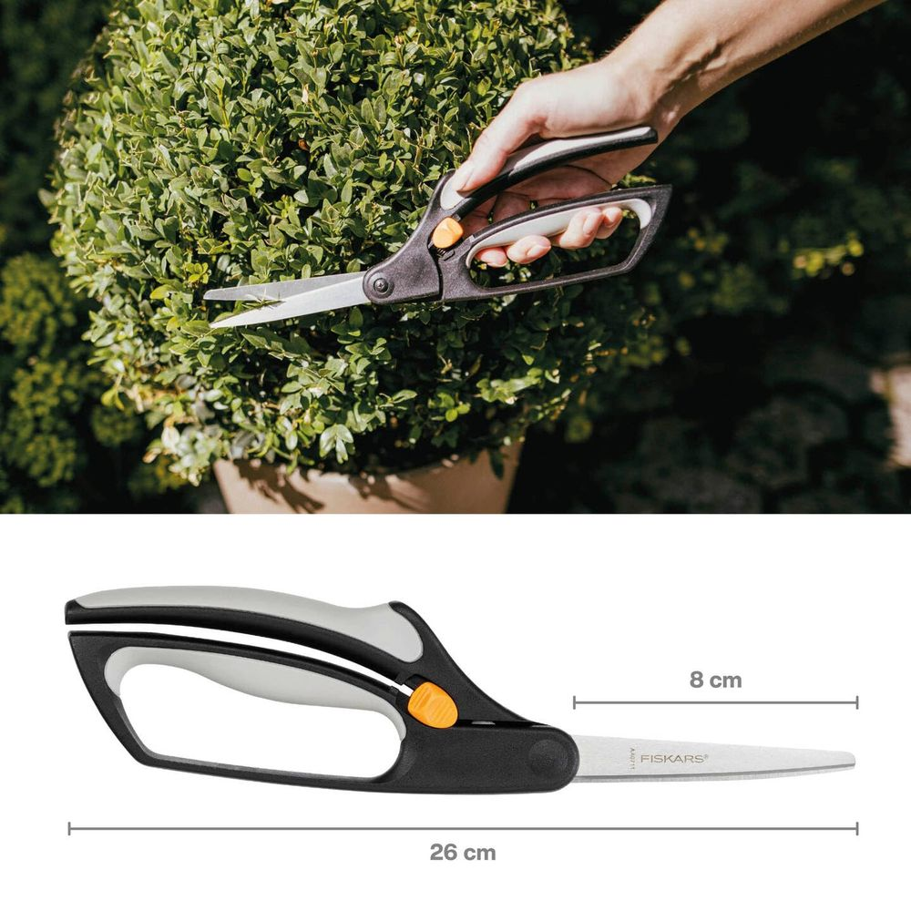 Hand schneidet grünen Busch mit Gartenschere; Maße: 26cm lang, 8cm Blatt.