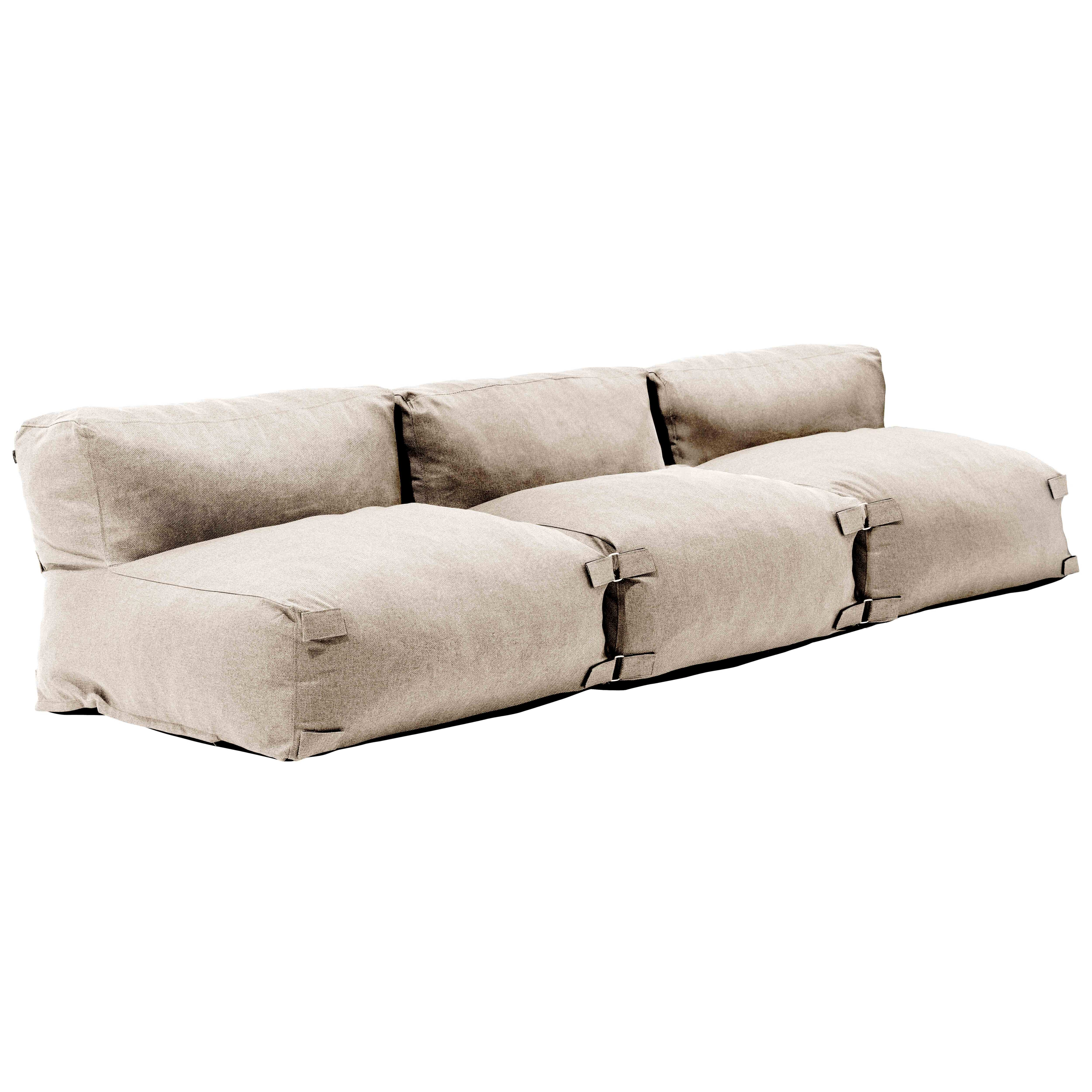 Ein beiger Stoffsofa mit drei Sitzkissen und Metallclips.