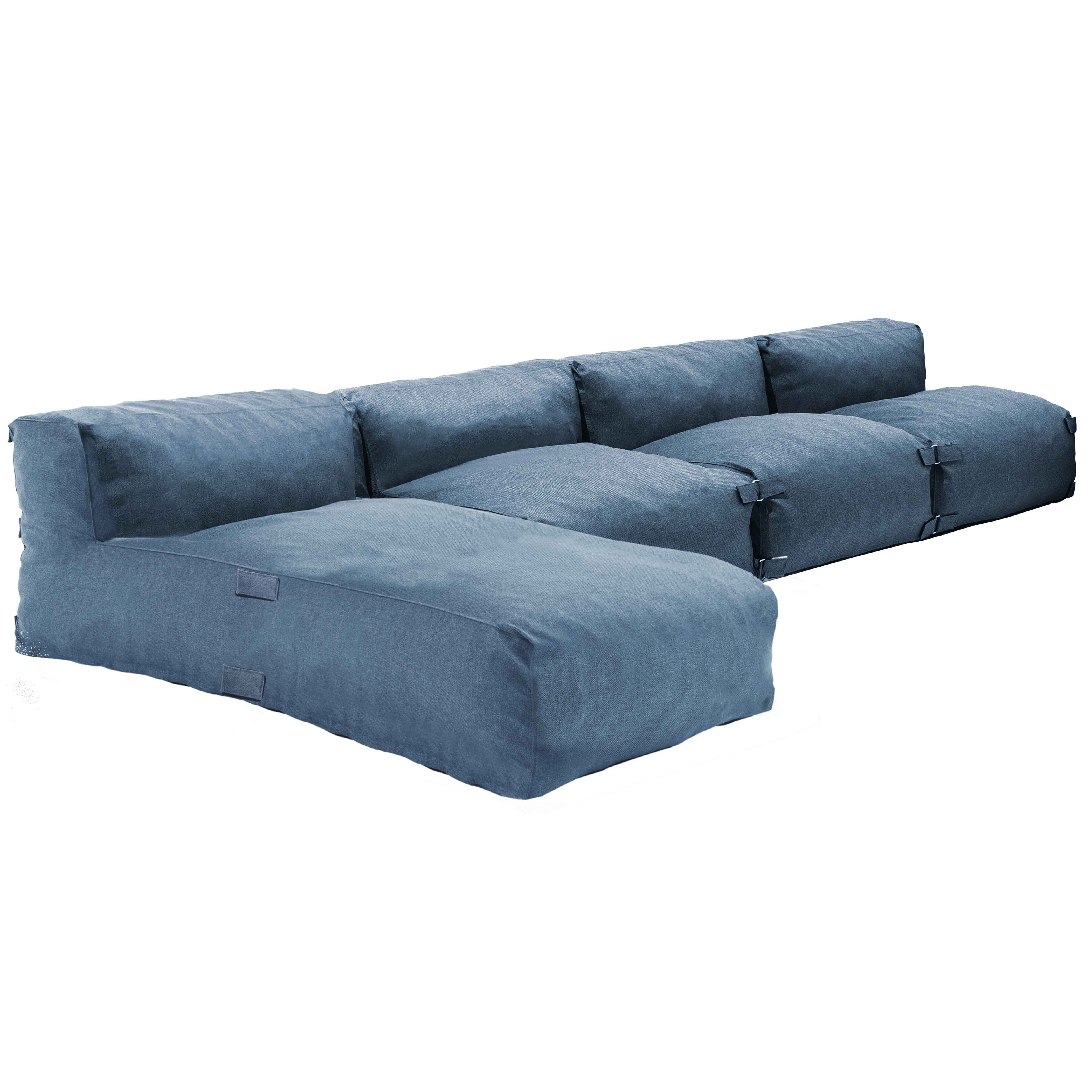 Ein modululares blaues Sofa mit mehreren Sitzkissen und einem abnehmbaren Hocker.
