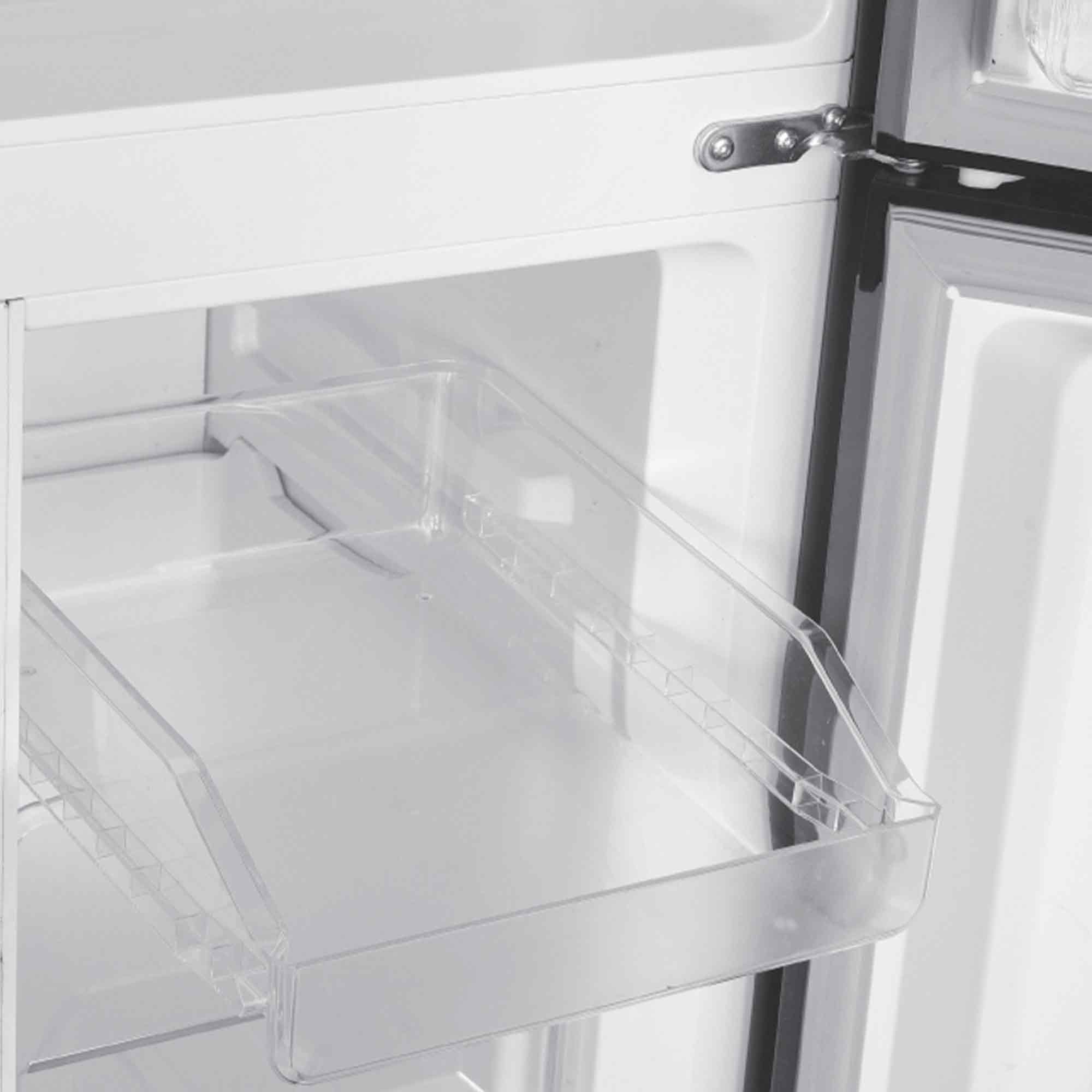 Ein leerer Kühlschrank mit transparenten Schubladen und einem Scharnier.
