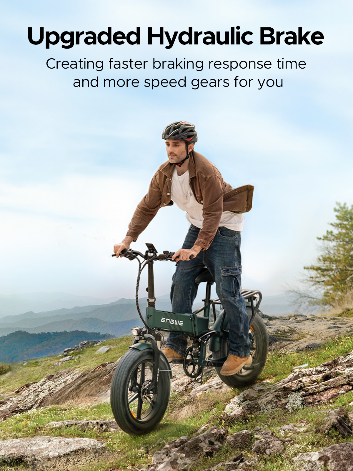 Hombre montando una bicicleta eléctrica verde en una colina rocosa con montañas.