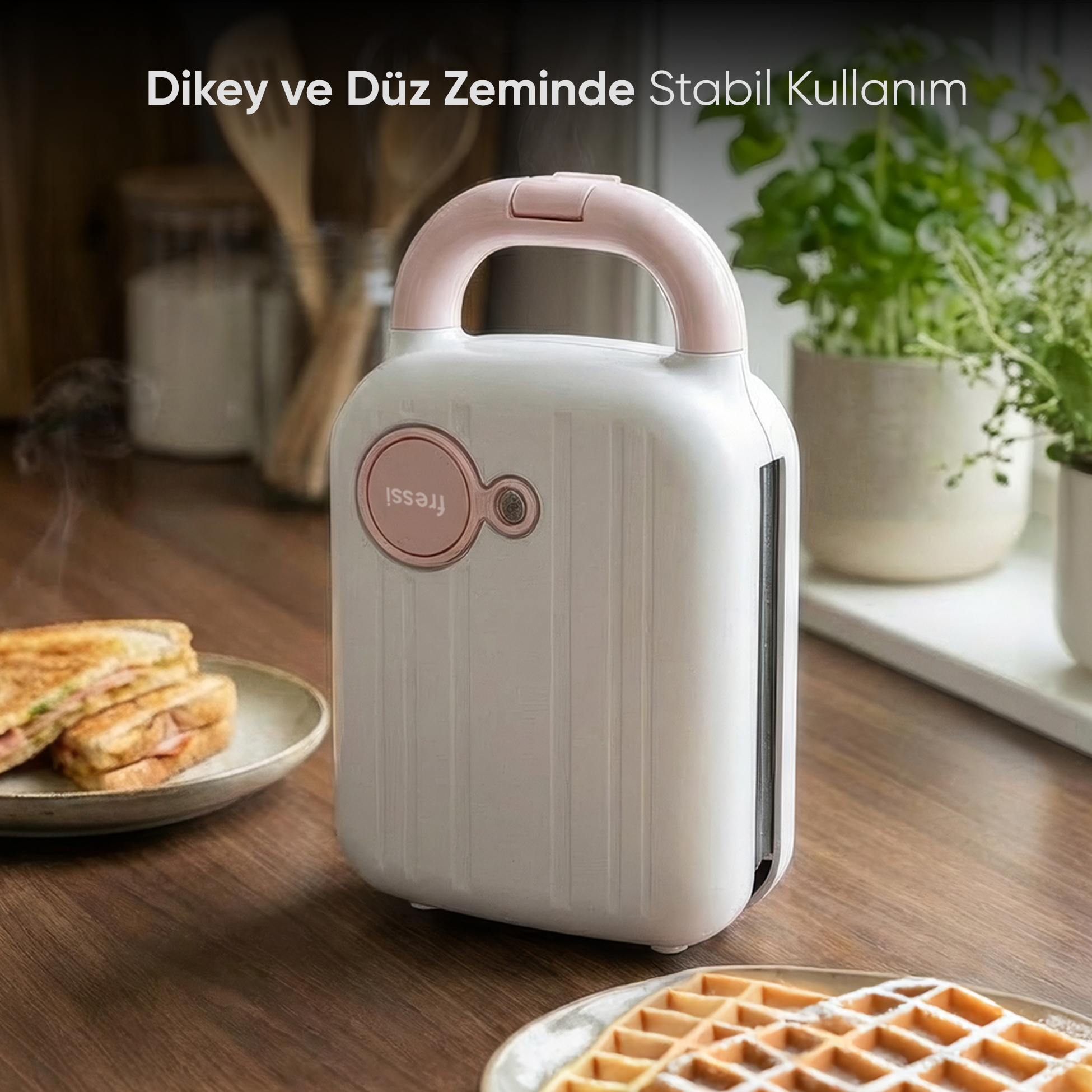 Pembe saplı beyaz sandviç makinesi, yanında tost ve waffle bulunur.