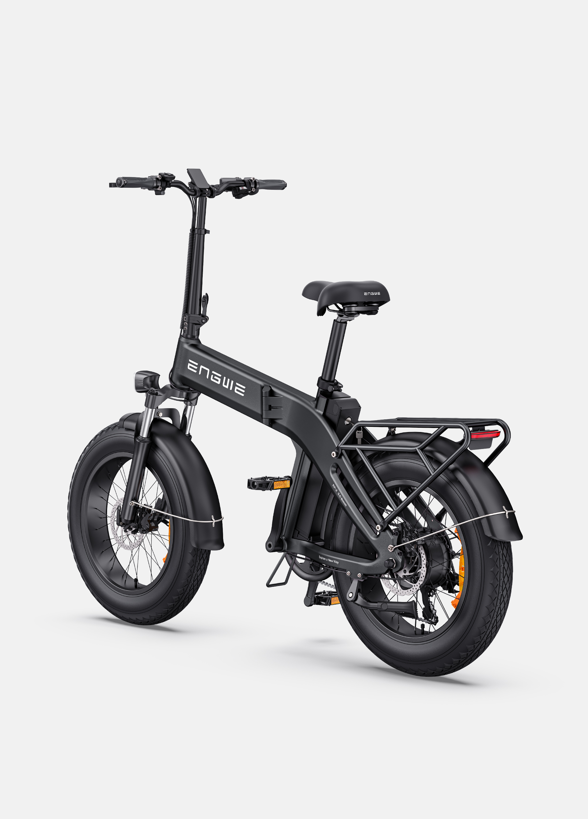 Una bicicleta eléctrica negra con neumáticos anchos y portabultos trasero sobre fondo gris.