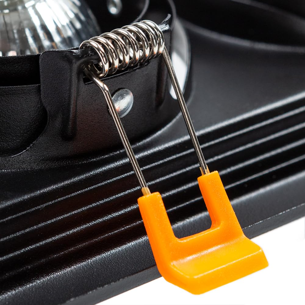 Nahaufnahme einer schwarzen Leuchte mit orangefarbenen Halteklammern und Metallfeder.