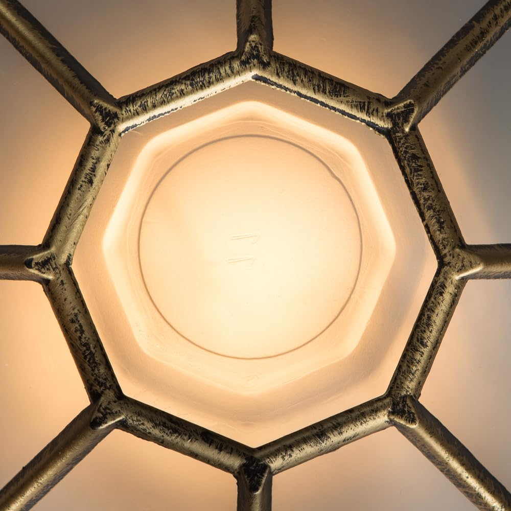 Ein detaillierter Blick auf eine sechseckige, goldfarbene Metallstruktur, die ein milchig-weißes Licht umgibt.
