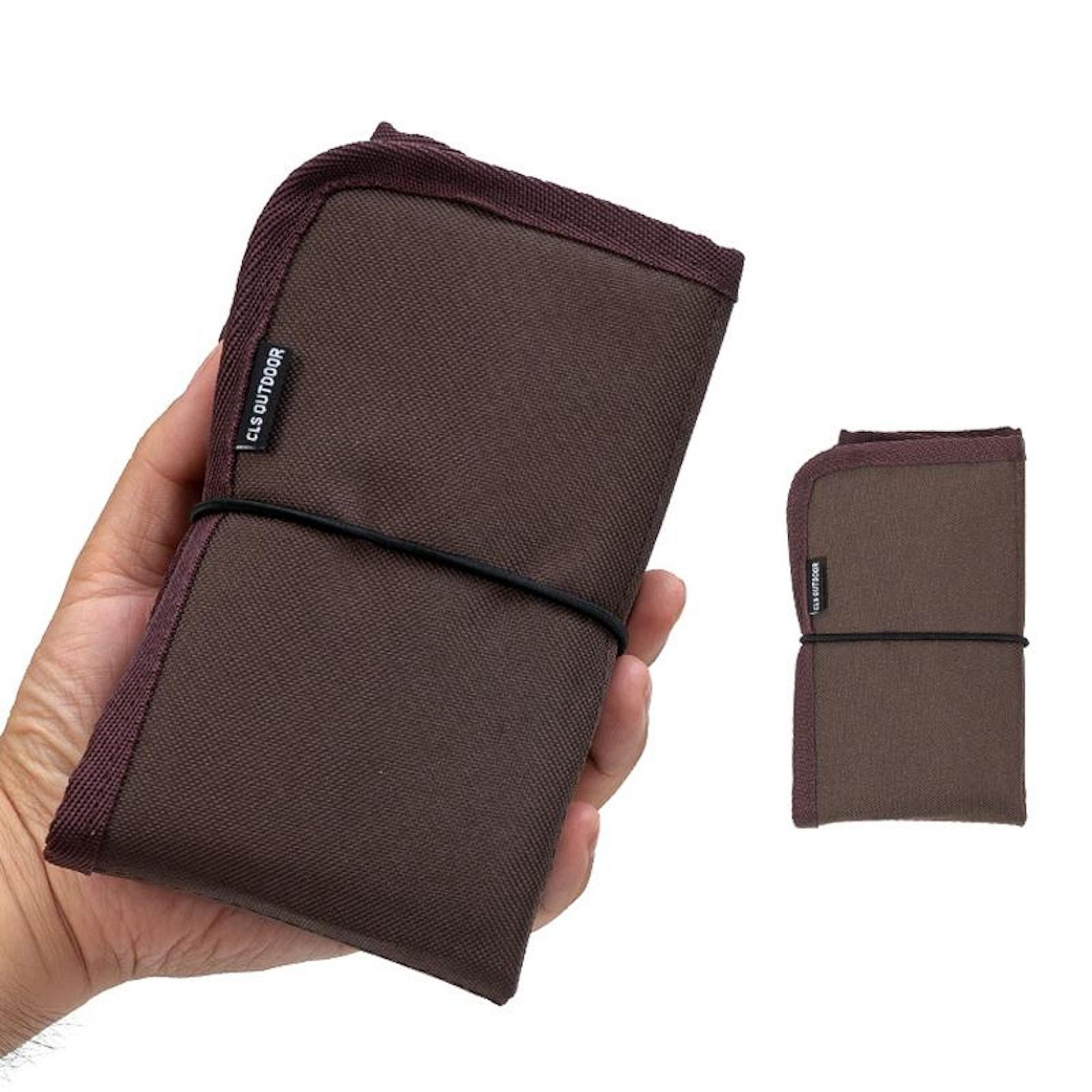 Braune Stofftasche mit schwarzem Gummiband, die von einer Hand gehalten wird.
