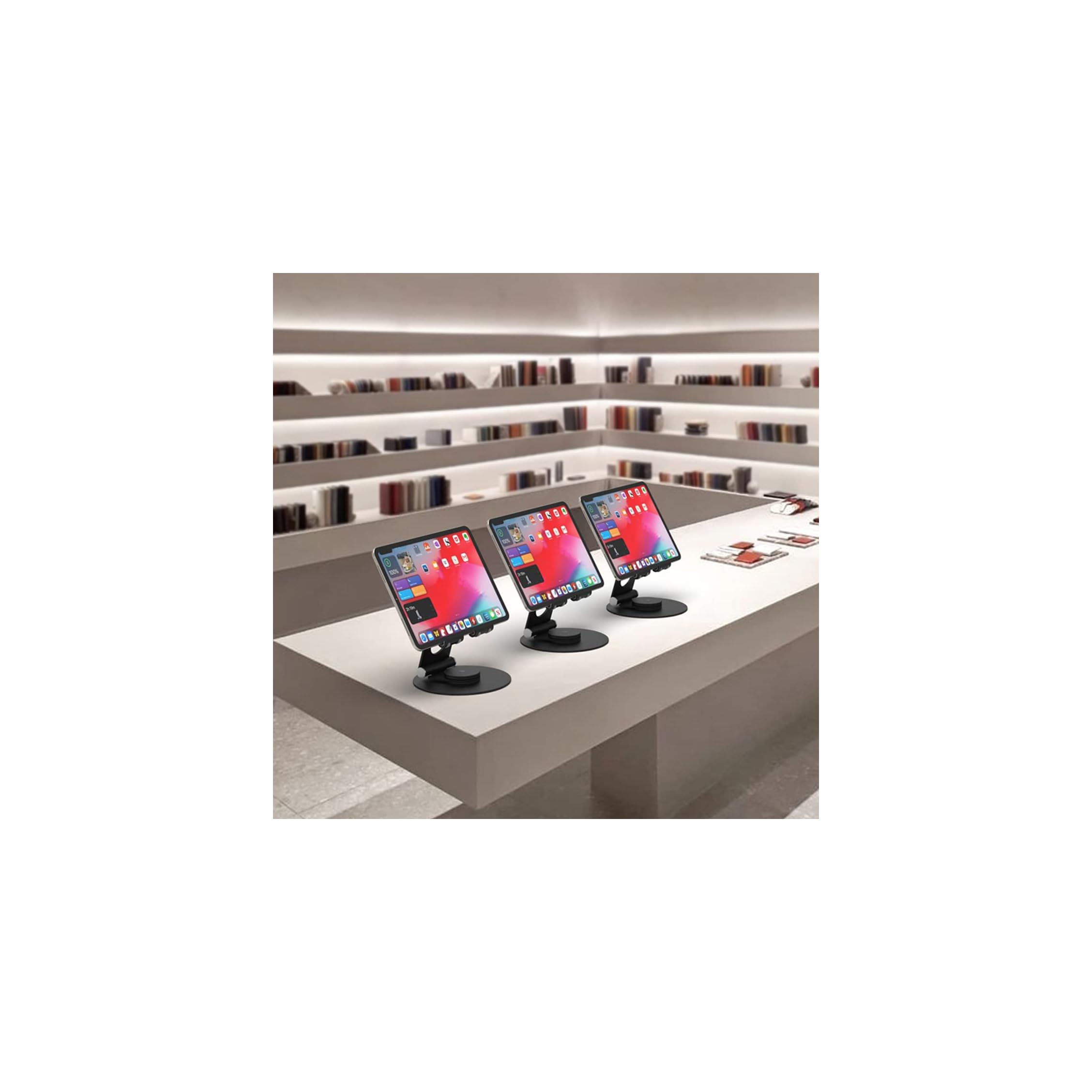 Drei Tablets mit bunten Bildschirmen stehen auf einer weißen Theke in einem Geschäft.