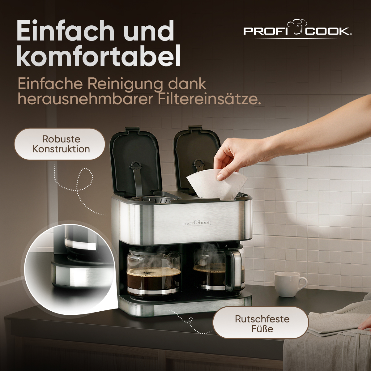 Eine silberne Kaffeemaschine mit zwei Glaskaraffen, eine Hand legt einen Kaffeefilter ein.