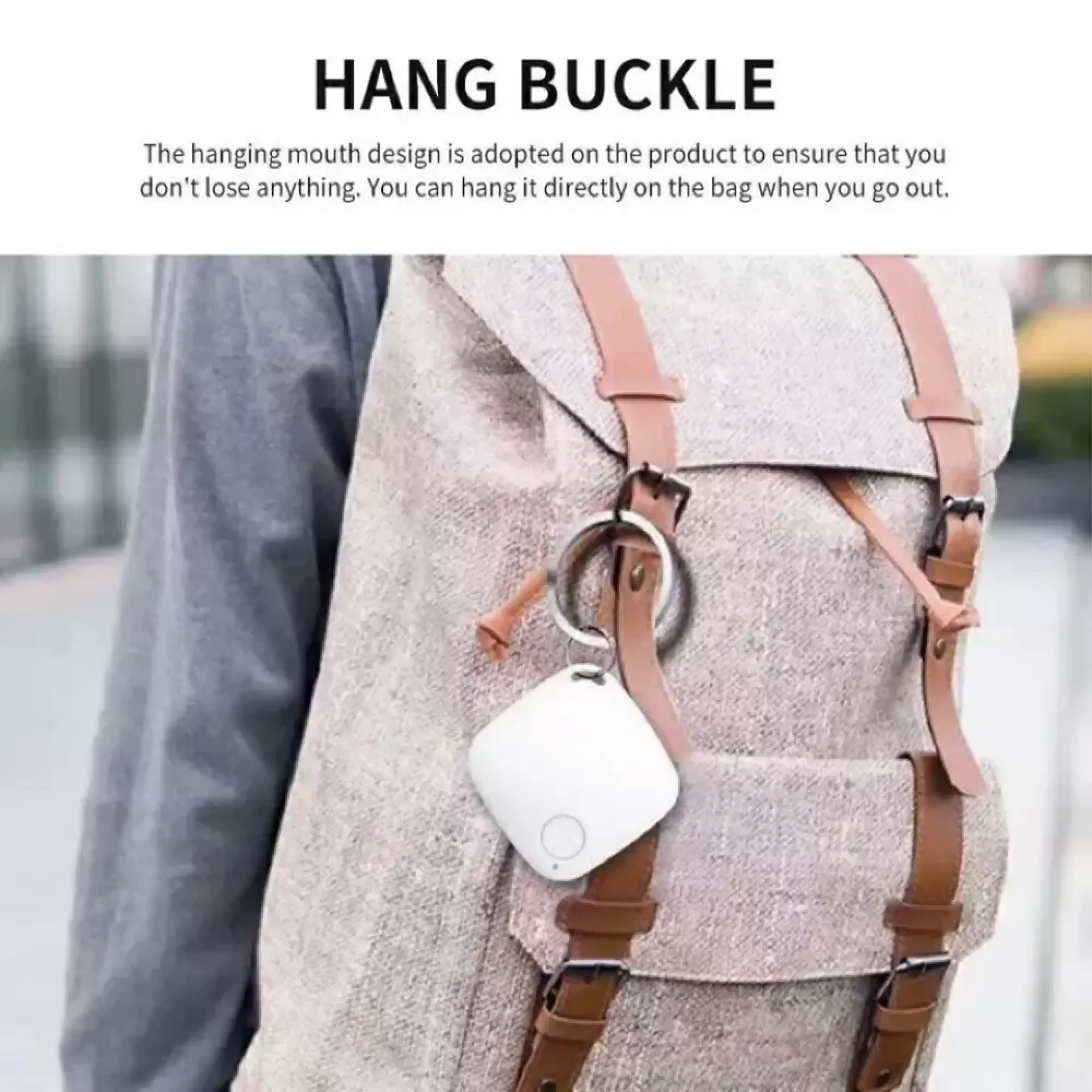 Ein weißer Tracker hängt an einer Tasche mit braunen Riemen.