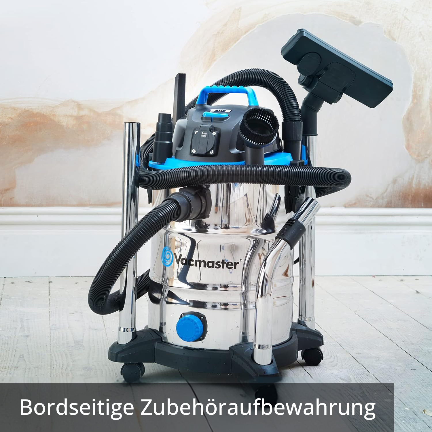 Ein silberner Nass-/Trockensauger mit blauem Griff und Zubehör auf einem Holzboden.