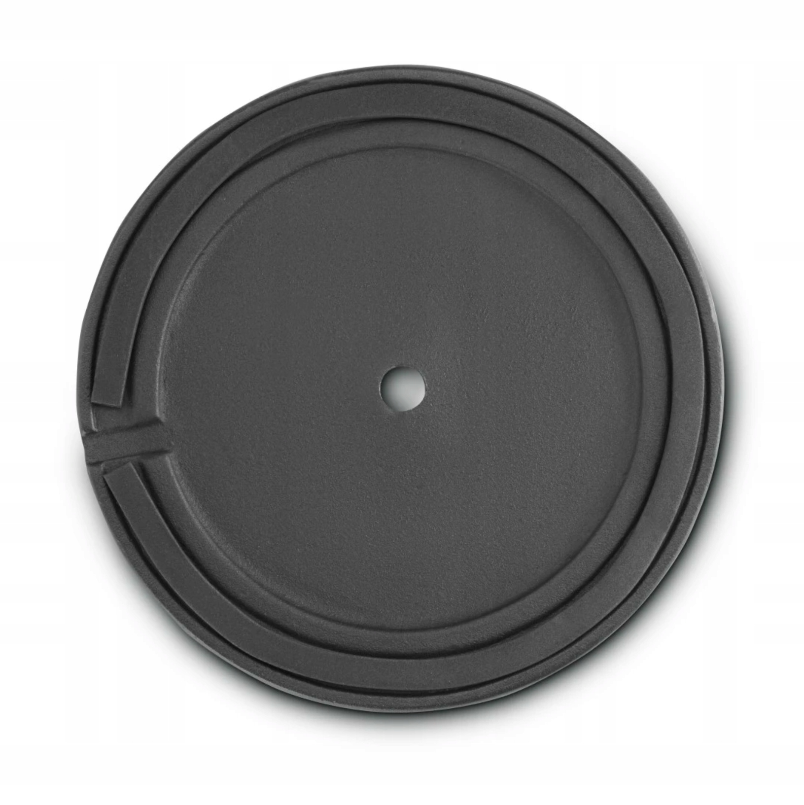 Ein grauer, runder Deckel mit einem Loch in der Mitte und konzentrischen Rillen.