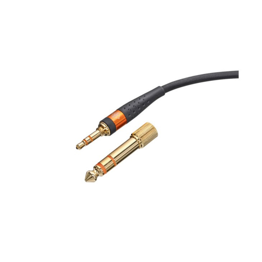 Ein goldener 6,3-mm-Adapter liegt neben einem 3,5-mm-Klinkenstecker mit Kabel.