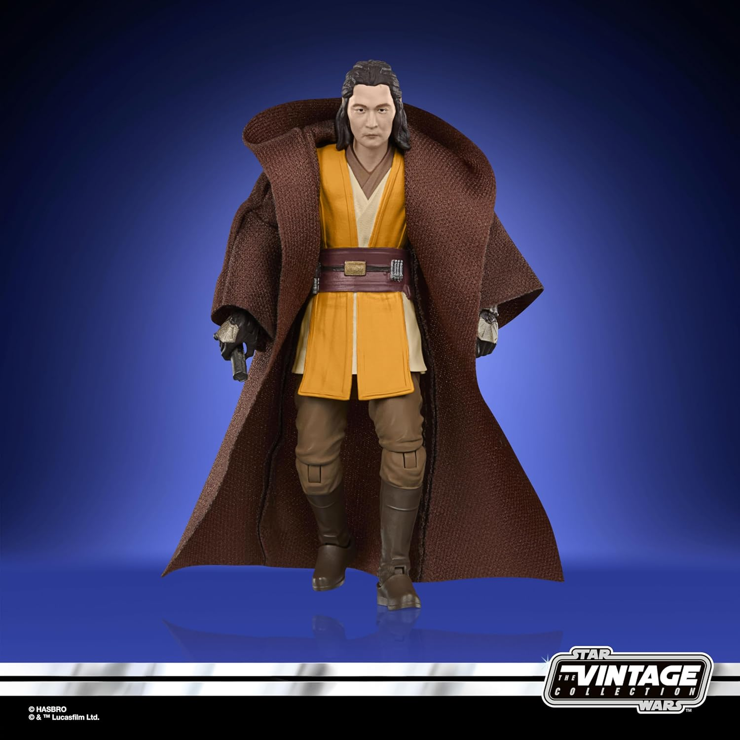 Actionfigur eines Mannes in braunem Umhang, gelber Tunika und braunen Hosen.