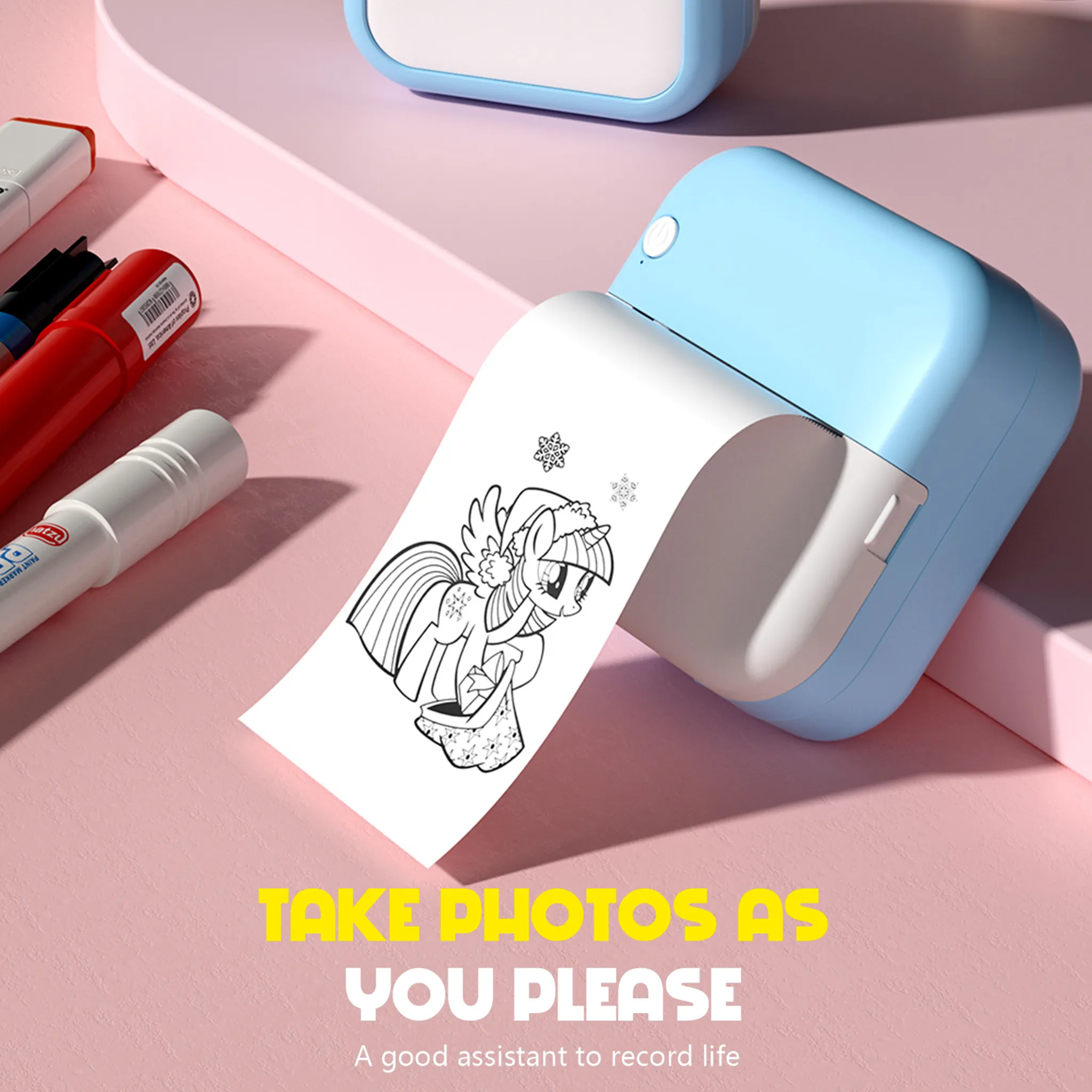 Ein blauer Drucker druckt ein Bild eines Ponys mit einem Geschenk aus. Stifte liegen daneben.