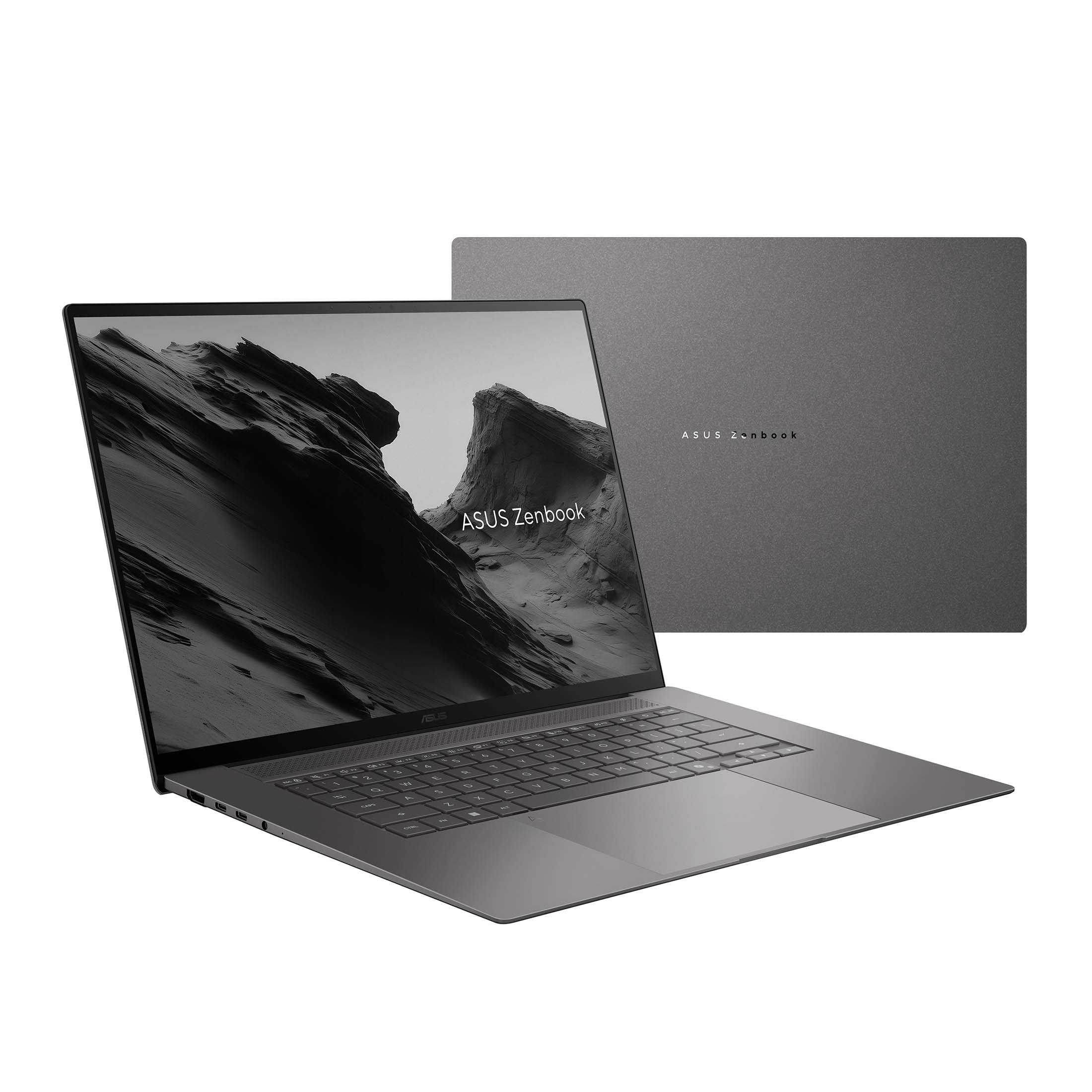 Un ordinateur portable Asus Zenbook gris avec écran et clavier illuminés.