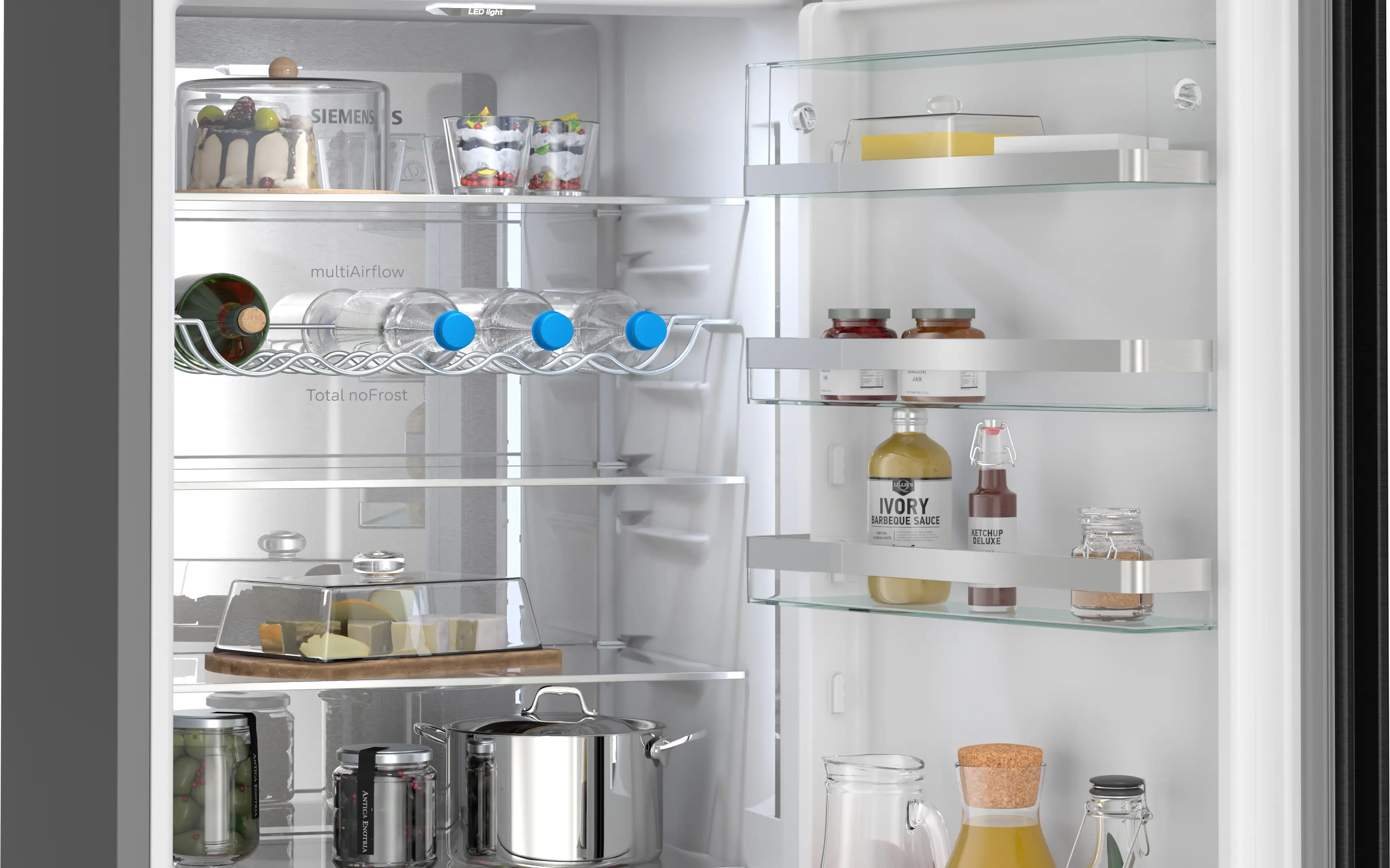 Refrigerador lleno con pastel, botellas, vasos, queso y ollas.