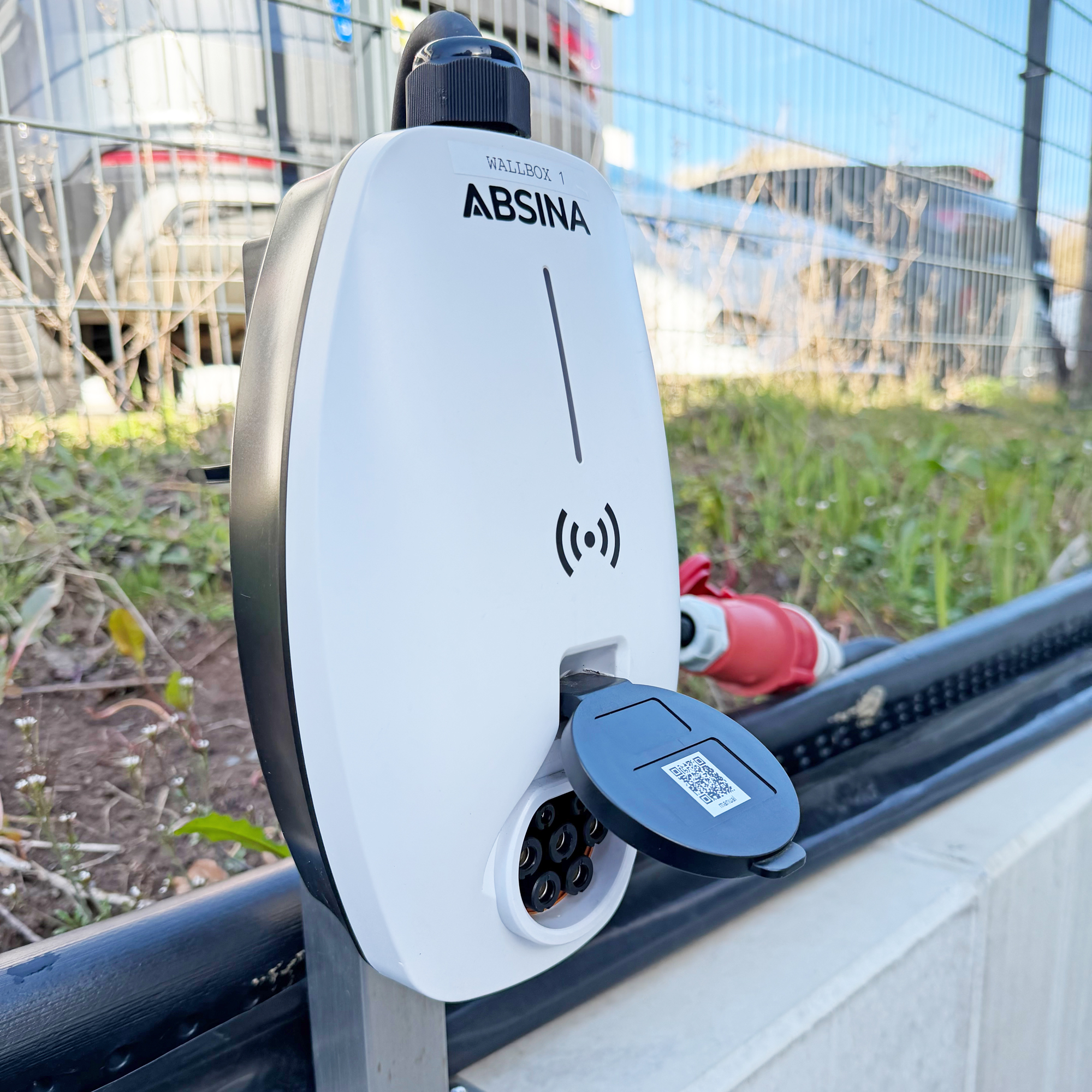 Weiße ABSINA Wallbox 1 mit geöffneter Ladebuchse und QR-Code.