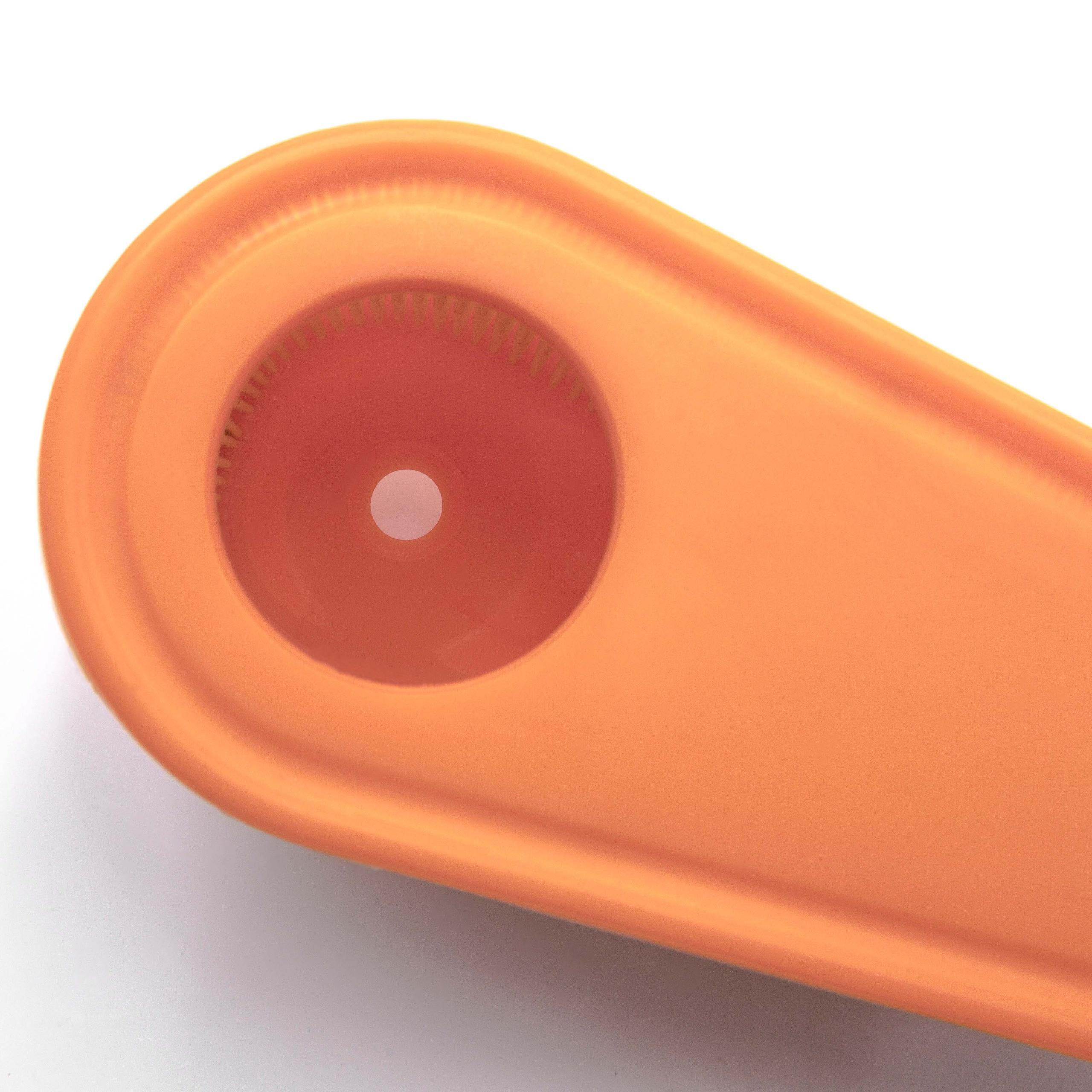 Ein oranges Objekt mit einem kreisförmigen Ausschnitt und Zähnen.