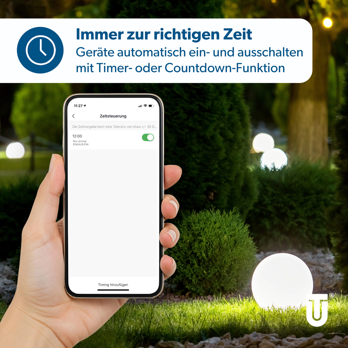 Hand hält Smartphone mit Zeitsteuerungs-App vor beleuchtetem Garten.