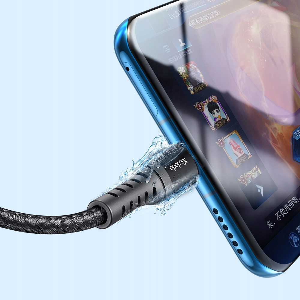 Gri bir şarj kablosu, bir oyunu gösteren mavi bir akıllı telefona takılıyor.