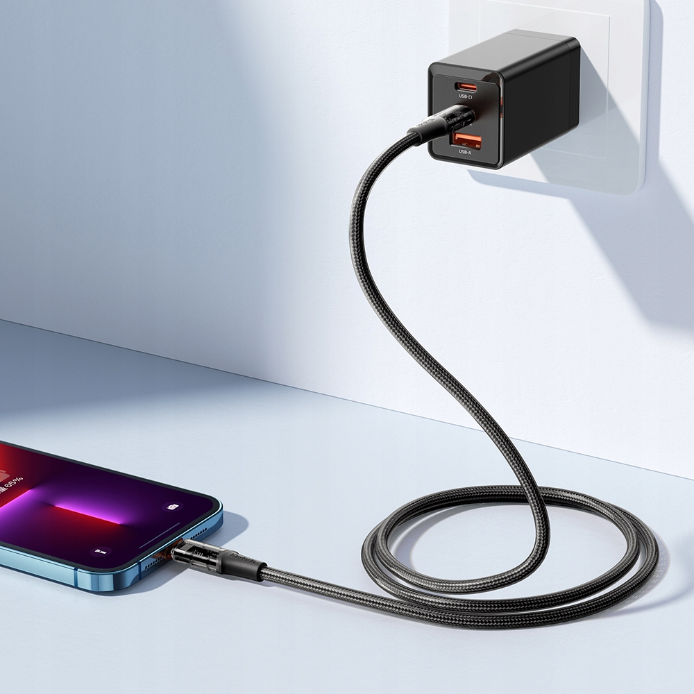 İki portlu siyah bir USB-C şarj cihazı prize takılı, telefonu şarj ediyor.