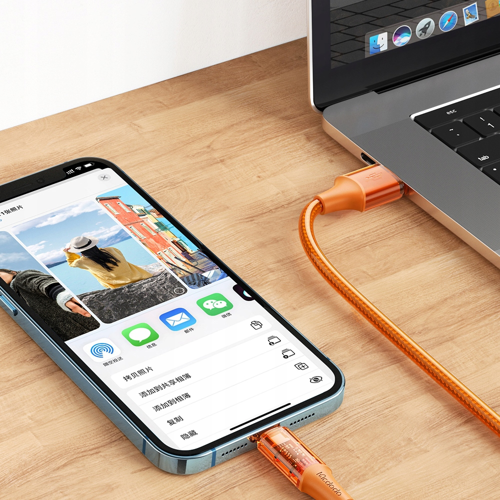 Telefon, turuncu USB-C kablosuyla dizüstü bilgisayara bağlı. Telefon ekranında fotoğraf paylaşım seçenekleri gösteriliyor.