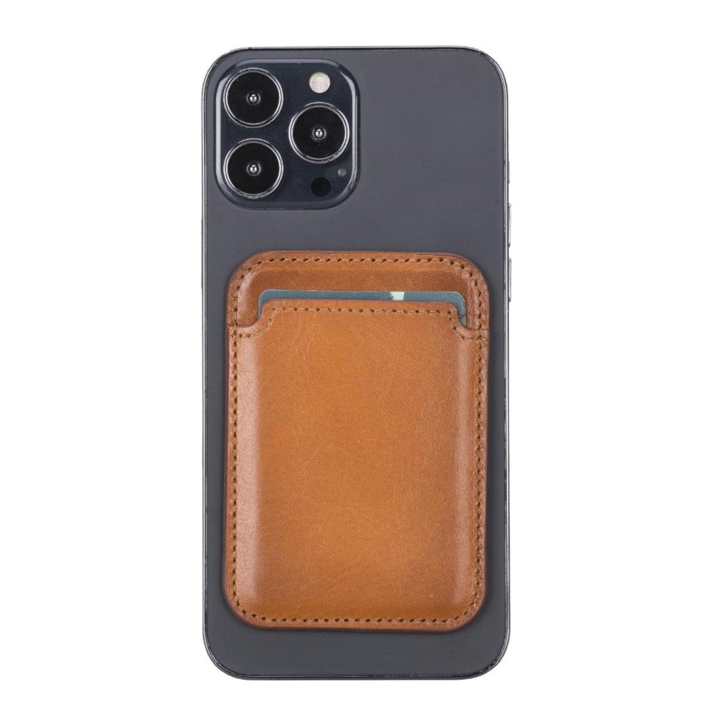 Kartlı kahverengi deri cüzdan, koyu renkli bir iPhone'un arkasına takılıdır.
