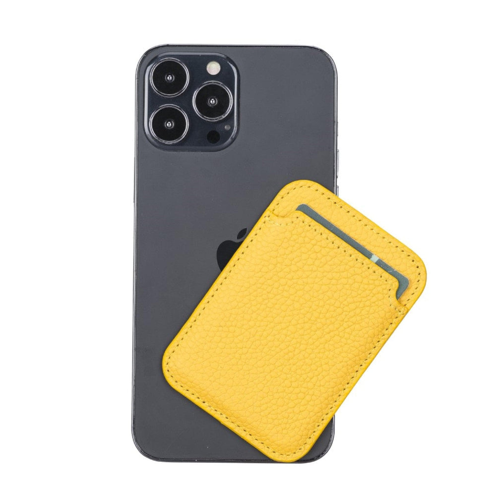 Sarı deri kartlık, koyu renkli bir iPhone'un arkasına yapışır.