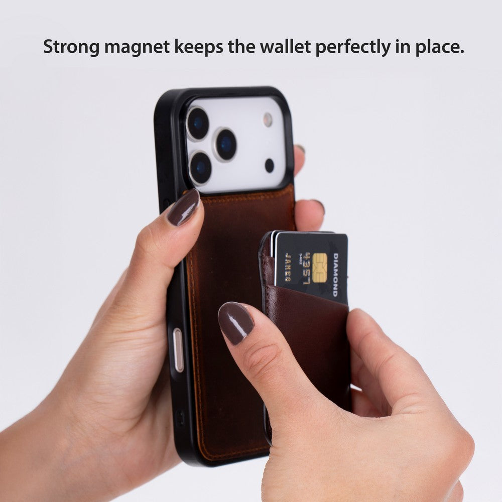 Eller iPhone'a takılı kahverengi deri telefon cüzdanına kredi kartı takıyor.