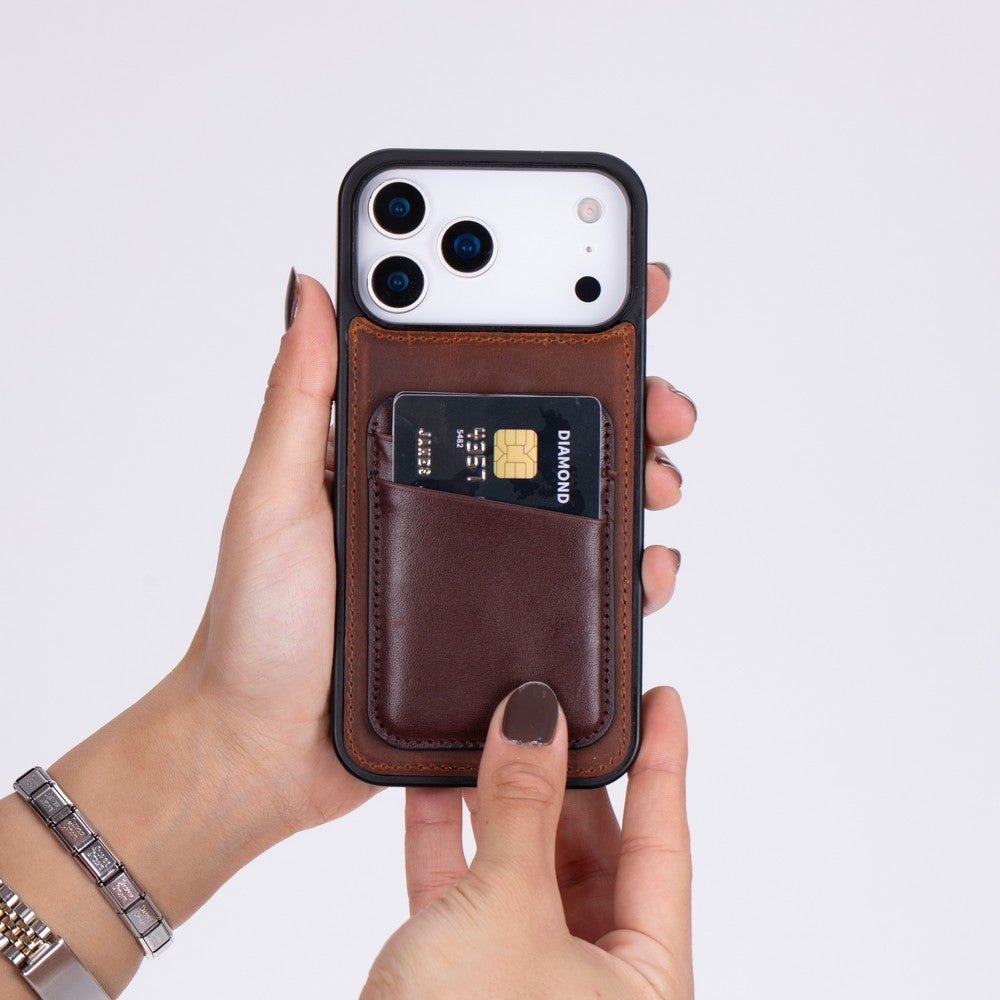 Arkada siyah kart tutan kahverengi deri kartlıklı bir telefon.