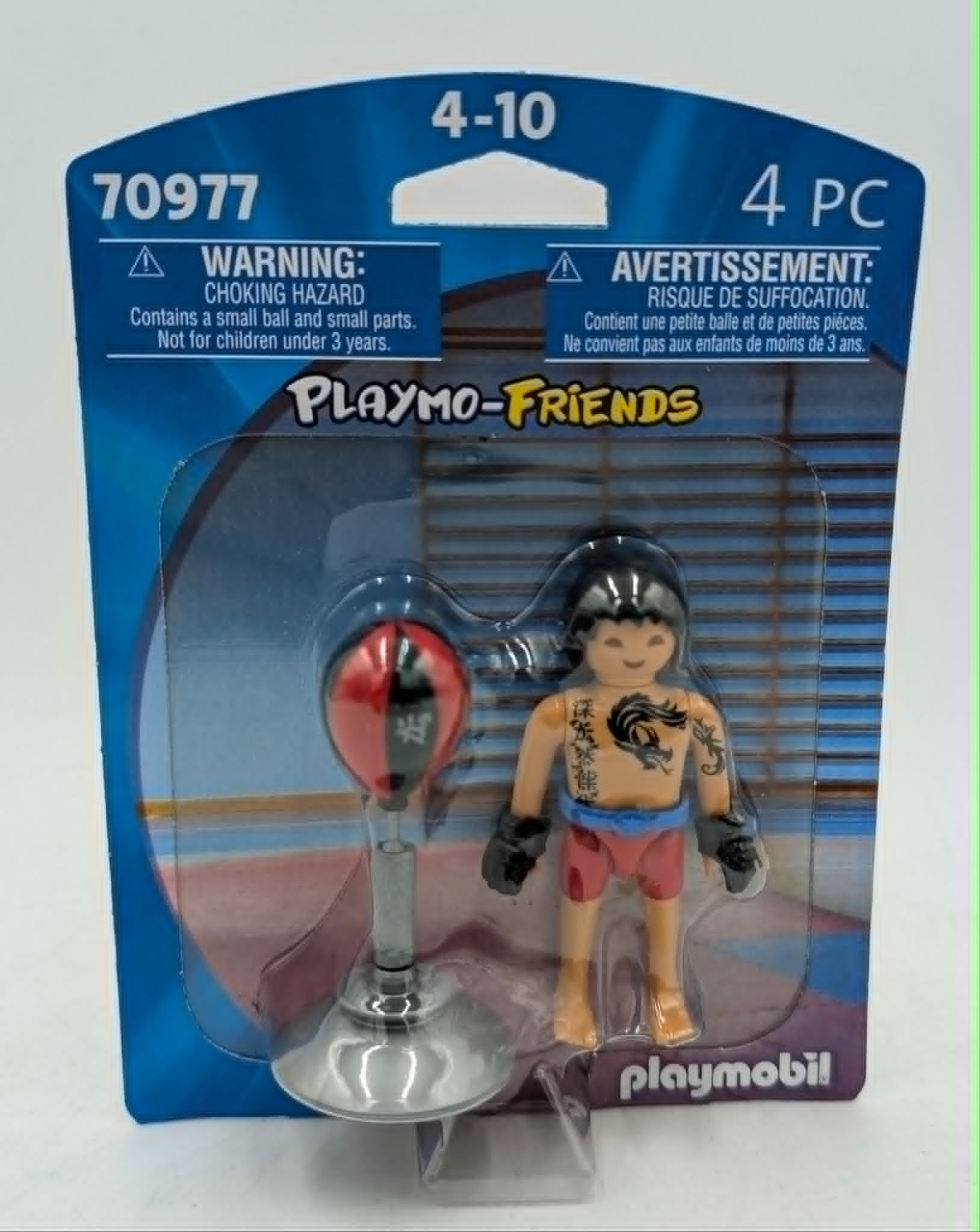 Figurka Playmobil z workiem treningowym w opakowaniu, z etykietą ostrzegawczą.