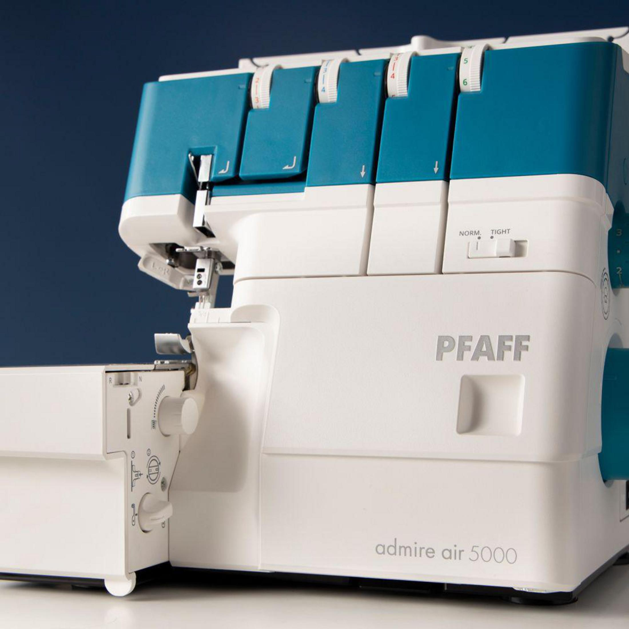 Una máquina de coser Pfaff blanca y turquesa con diales de control.