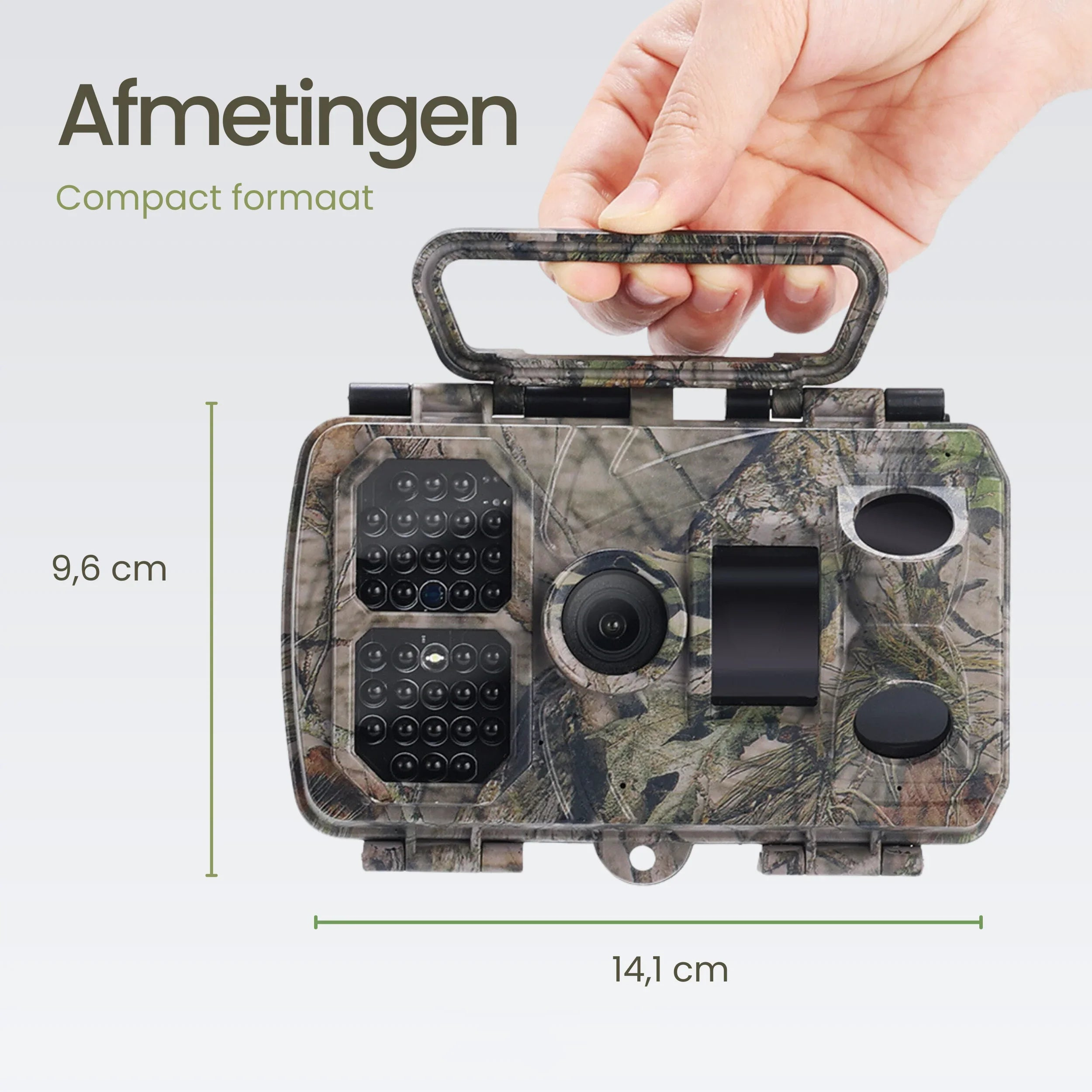 A hand holds a camouflage trail camera, dimensions 9.6x14.1 cm.