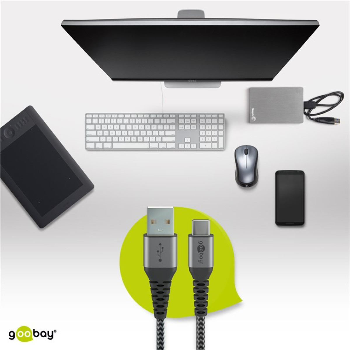 Computer setup with monitor, keyboard, mouse, tablet, phone, external drive, and USB-C cable.